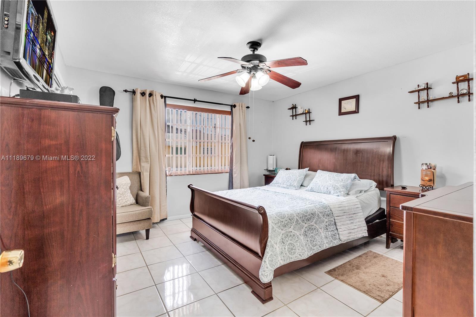 627 West 68th Street, Unit 627 Hialeah, FL 33014 - Photo 26 of 31 a bedroom with a bed and a chandelier
