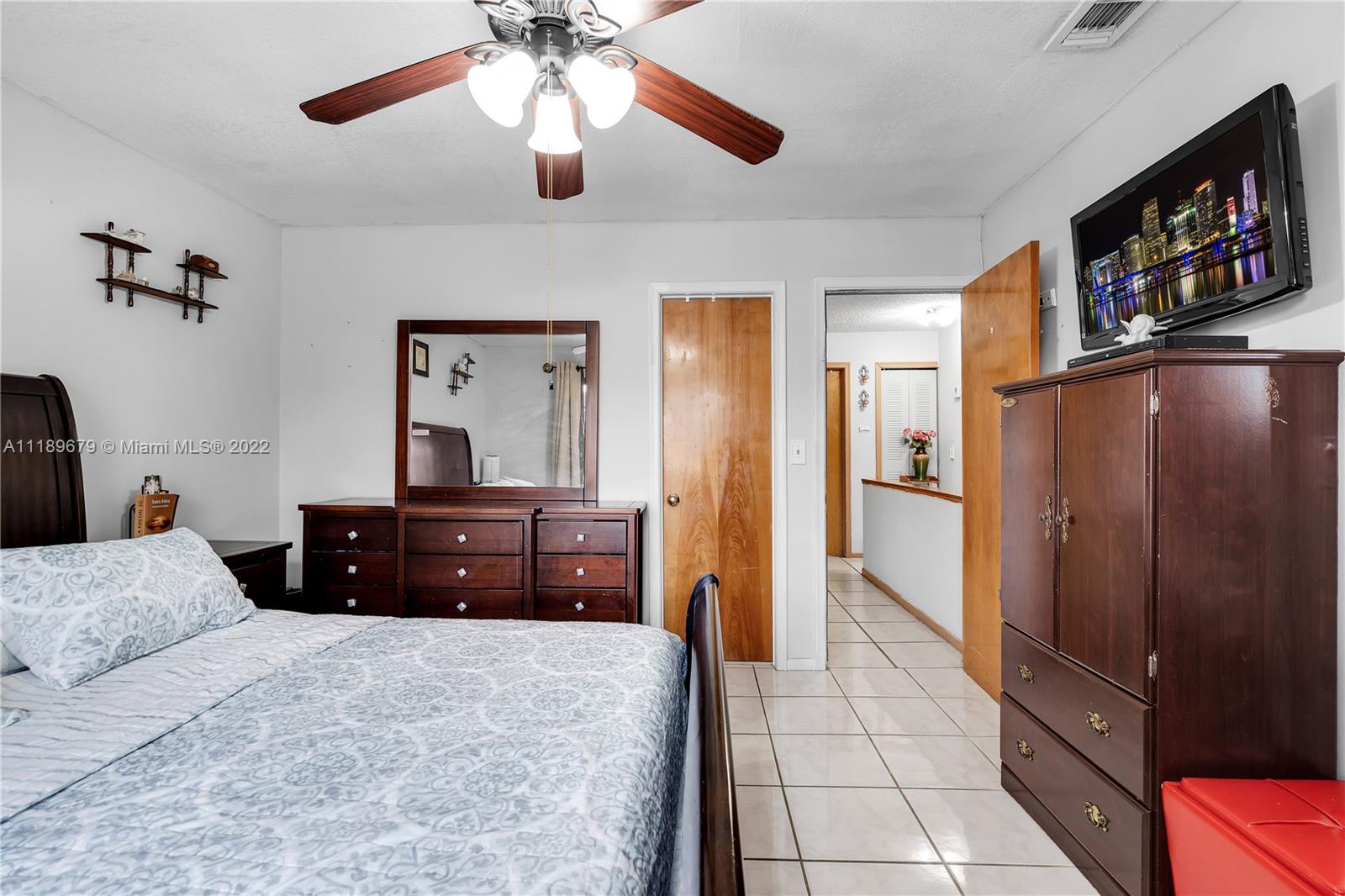 627 West 68th Street, Unit 627 Hialeah, FL 33014 - Photo 27 of 31 a bedroom with a bed and a chandelier
