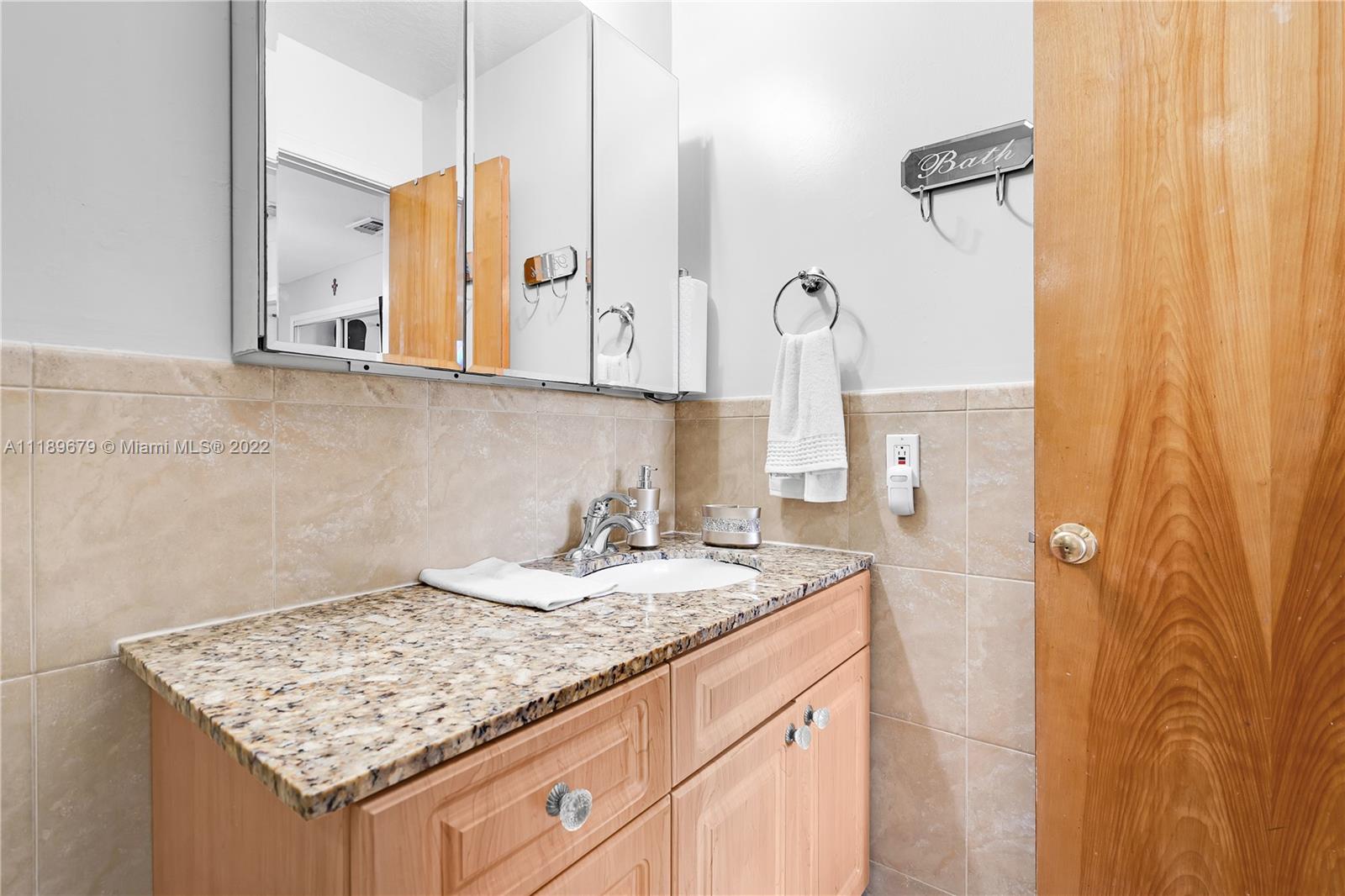 627 West 68th Street, Unit 627 Hialeah, FL 33014 - Photo 29 of 31 a bathroom with a granite countertop sink and a mirror