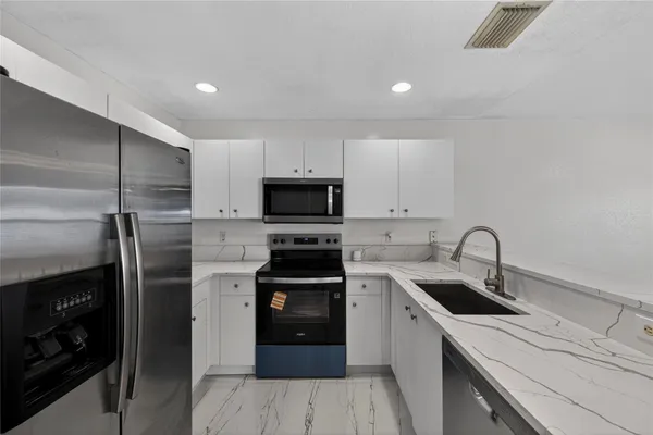 a kitchen with a sink appliances and cabinets