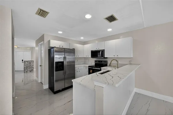 a kitchen with stainless steel appliances a refrigerator and a stove top oven