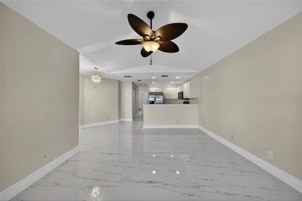 a view of an empty room and kitchen