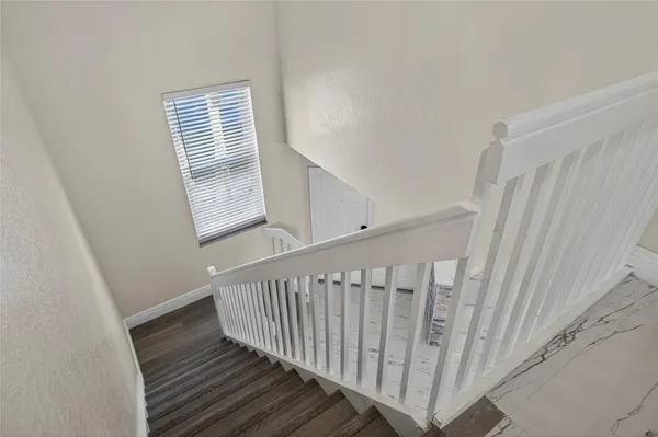 a view of staircase with white walls and a window