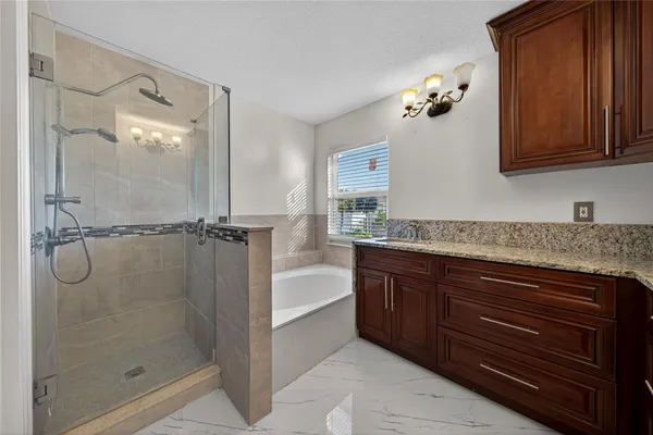 a bathroom with a granite countertop sink a mirror and shower