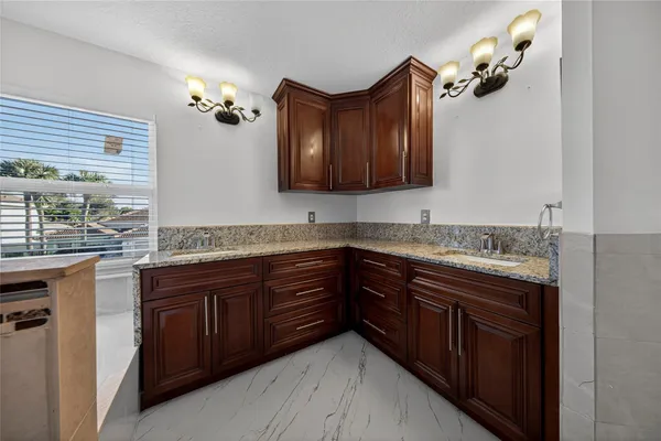 a bathroom with a granite countertop double vanity sink and mirror