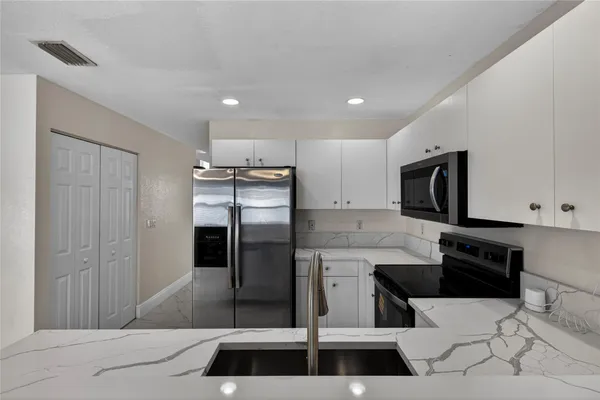 a kitchen with stainless steel appliances a refrigerator and a stove top oven