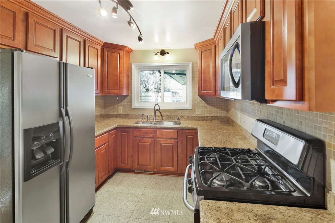 171 East Pole Road Lynden, WA 98264 - Photo 11 of 39 a kitchen with stainless steel appliances granite countertop a refrigerator a sink and wooden cabinets