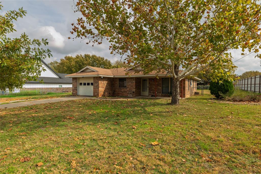 401 Berryhill Drive Springtown, TX 76082 - Photo 2 of 26 a front view of a house with a garden