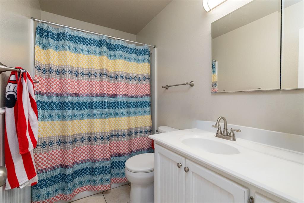 401 Berryhill Drive Springtown, TX 76082 - Photo 21 of 26 a bathroom with a sink a toilet and a shower curtain