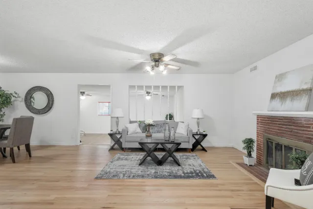 a living room with fireplace furniture and a wooden floor