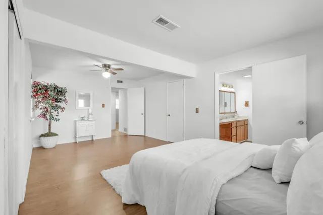 a spacious bedroom with a bed and a chandelier