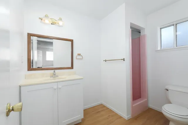 a bathroom with a toilet sink vanity and mirror