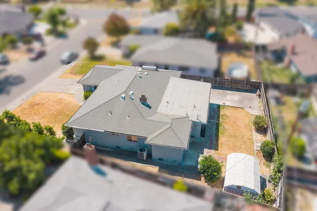 an aerial view of a house with a yard and pool