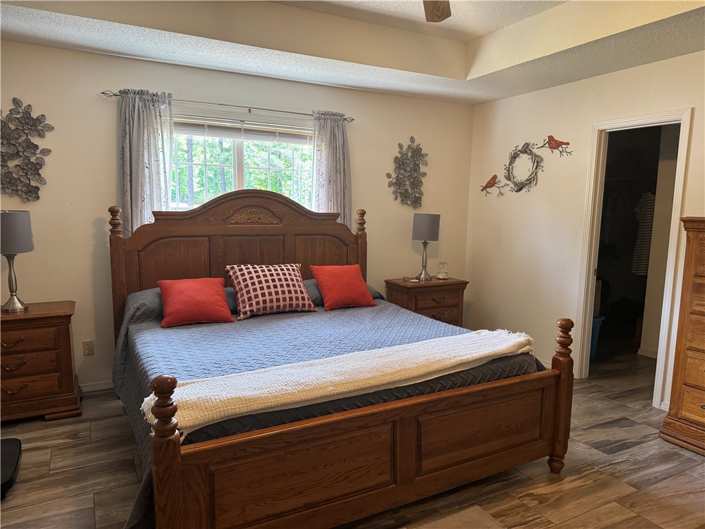 95 Deer Run Road Delaware, AR 72835 - Photo 31 of 40 Spacious room featuring wood-finish flooring, a tray ceiling, and a window with outdoor tree scenery