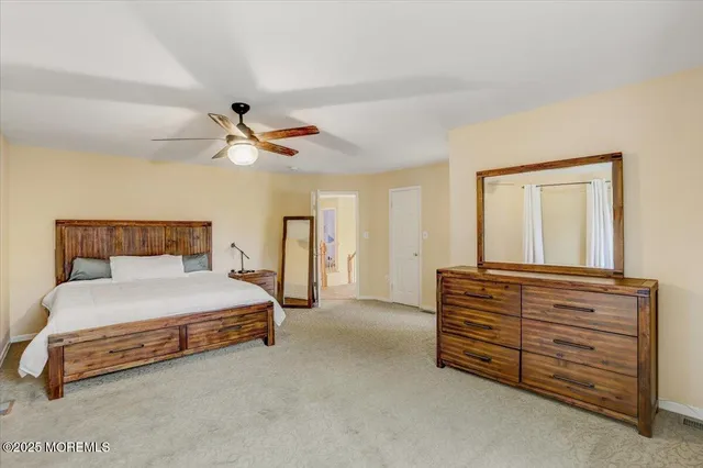 a bedroom with a bed and a ceiling fan