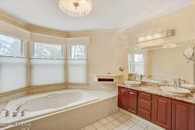 a spacious bathroom with a tub sink and mirror