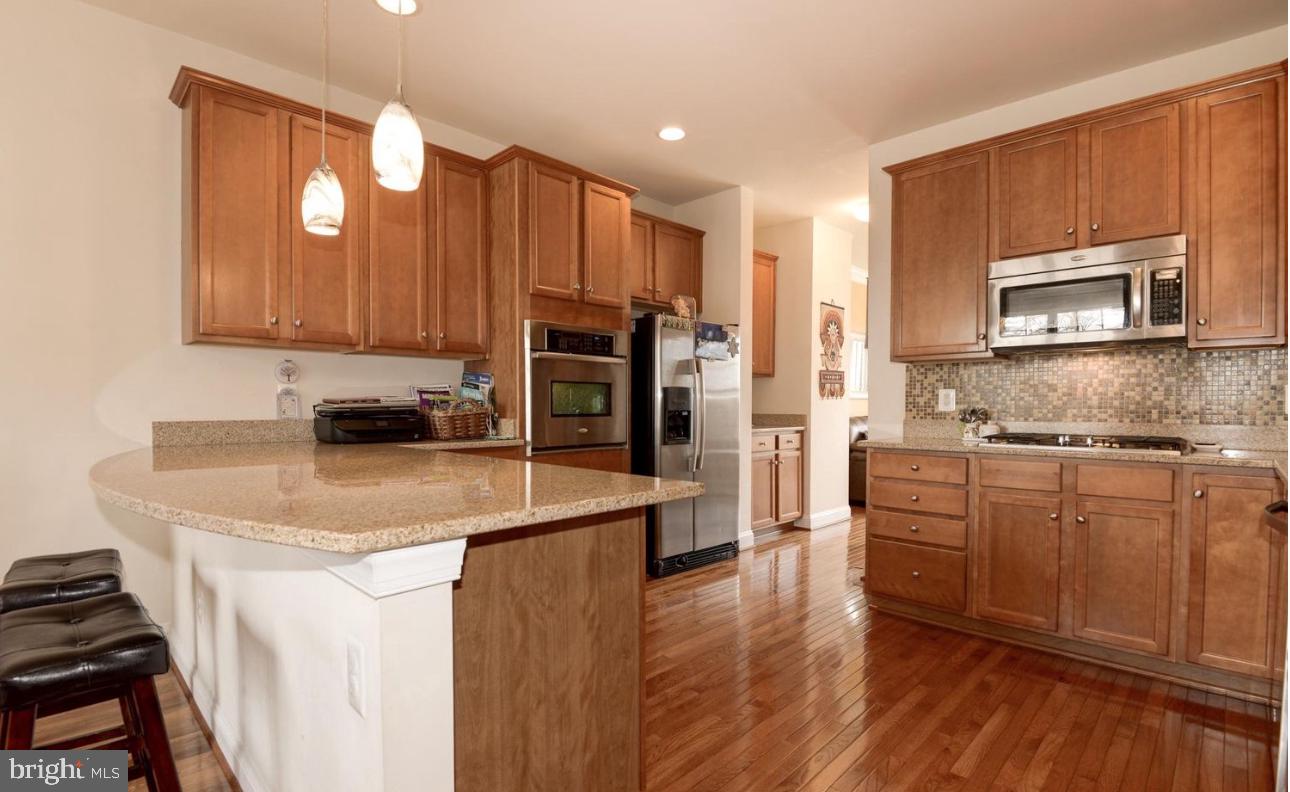 a kitchen with stainless steel appliances granite countertop wooden cabinets a stove a sink and dishwasher