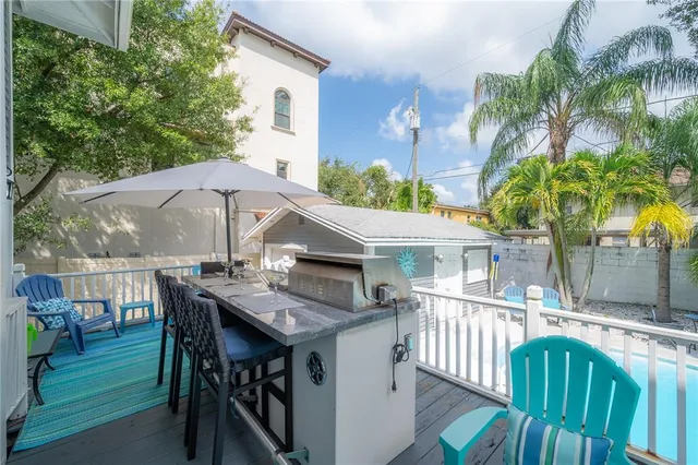 a view of a patio with table and chairs with wooden floor and fence