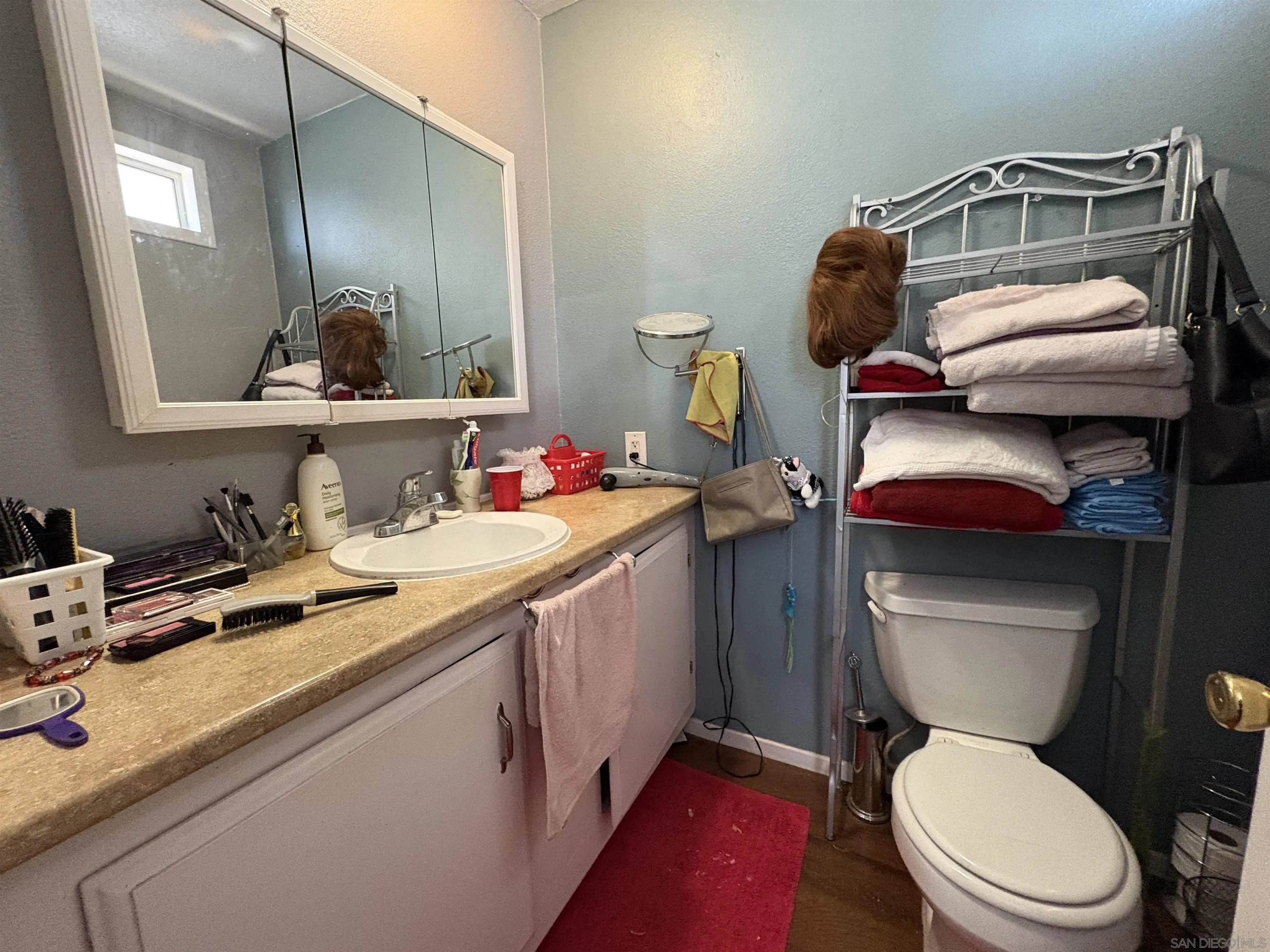 402 63rd Street, Unit 99 San Diego, CA 92114 - Photo 15 of 15 a bathroom with a toilet sink and mirror