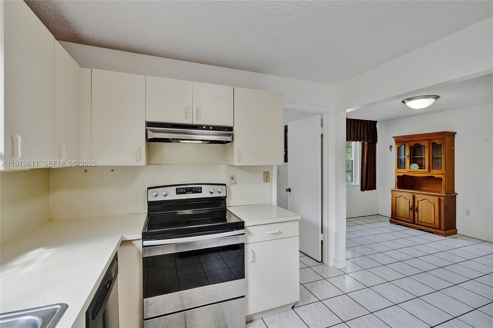 13401 Southwest 38th Street Miami, FL 33175 - Photo 15 of 45 a kitchen with white cabinets and stainless steel appliances
