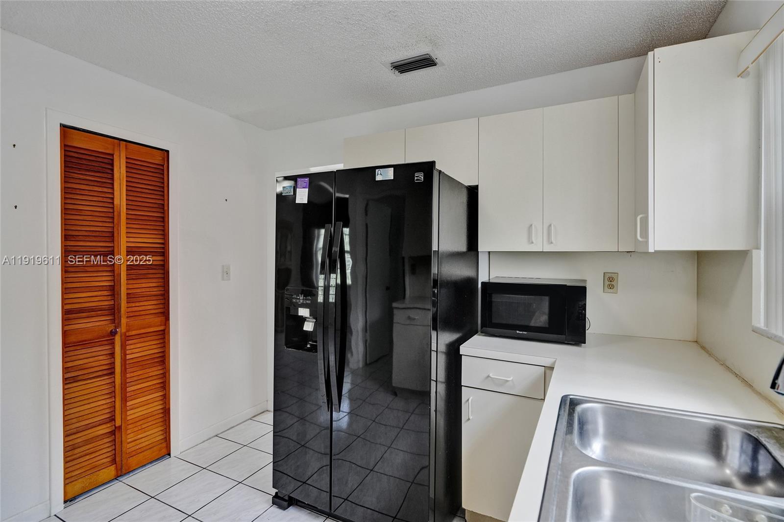 13401 Southwest 38th Street Miami, FL 33175 - Photo 16 of 45 a kitchen with a refrigerator and cabinets