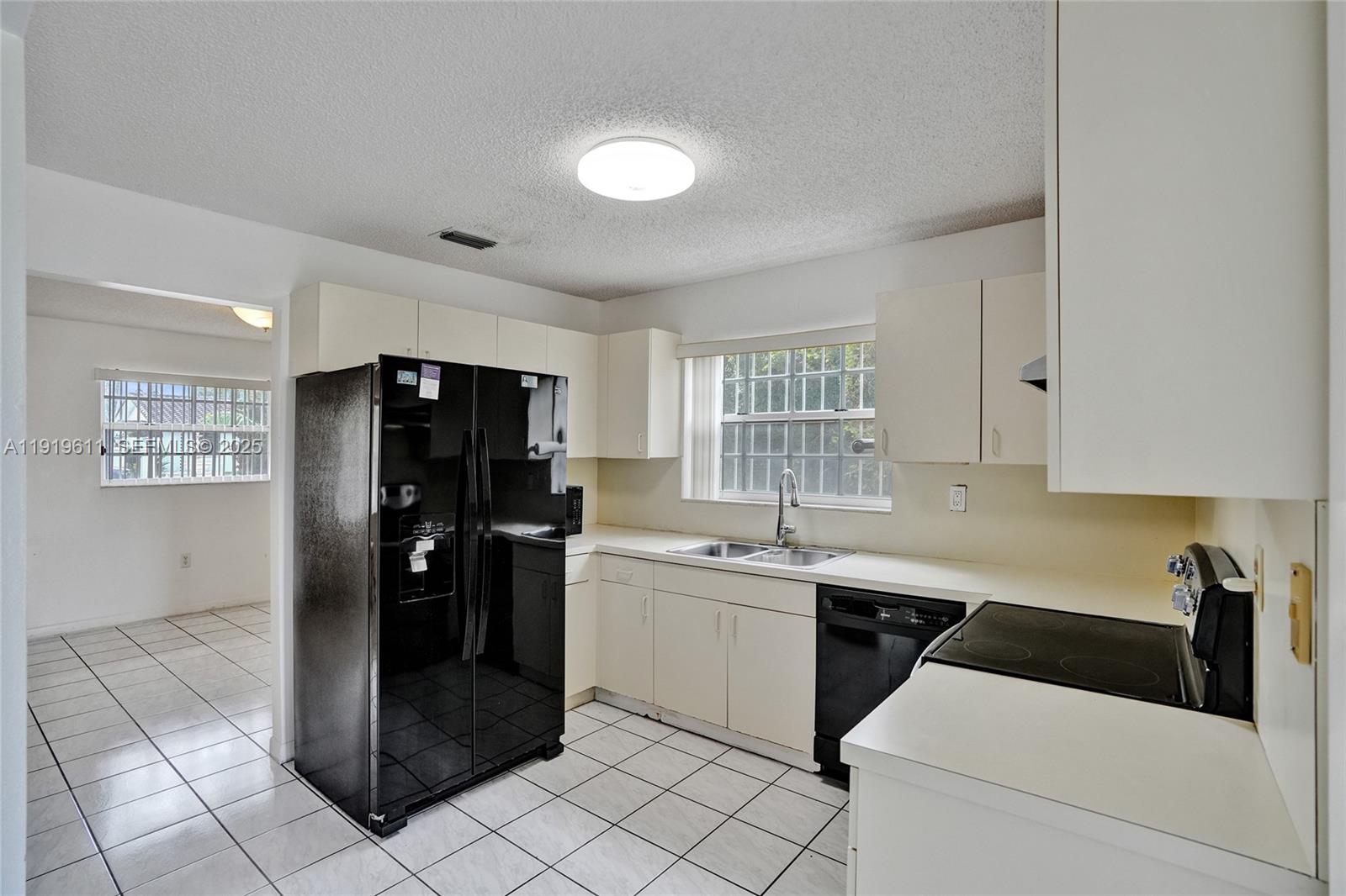 13401 Southwest 38th Street Miami, FL 33175 - Photo 19 of 45 a kitchen with a refrigerator and white cabinets
