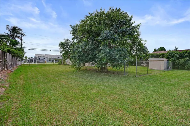 a view of yard with swimming pool and green space