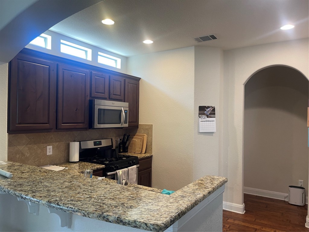 6708 Menchaca Road, Unit 11 Austin, TX 78745 - Photo 5 of 8 a kitchen with granite countertop wooden cabinets and a stainless steel appliances
