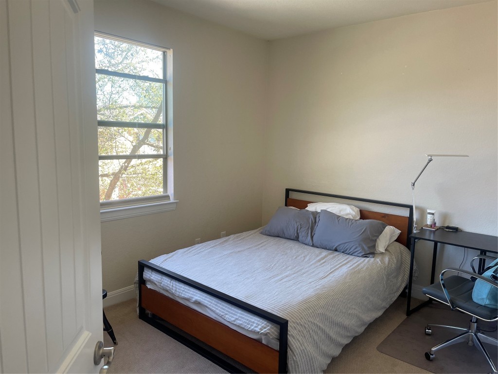 6708 Menchaca Road, Unit 11 Austin, TX 78745 - Photo 7 of 8 a bedroom with a bed and window