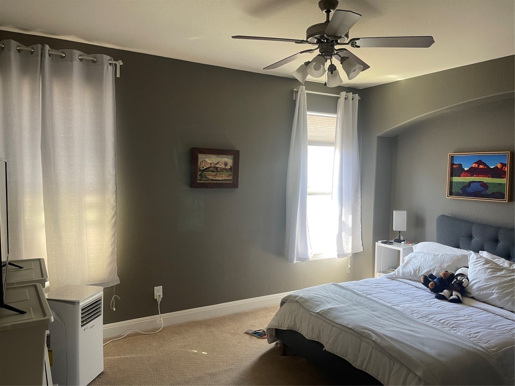 6708 Menchaca Road, Unit 11 Austin, TX 78745 - Photo 8 of 8 a bedroom with a bed and a chandelier