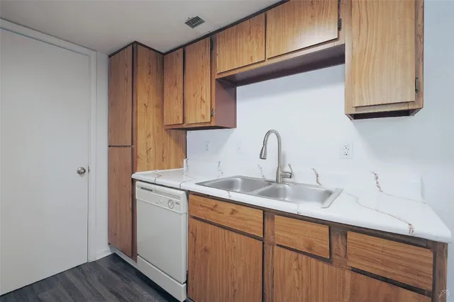 a kitchen with stainless steel appliances granite countertop a sink and cabinets with wooden floor