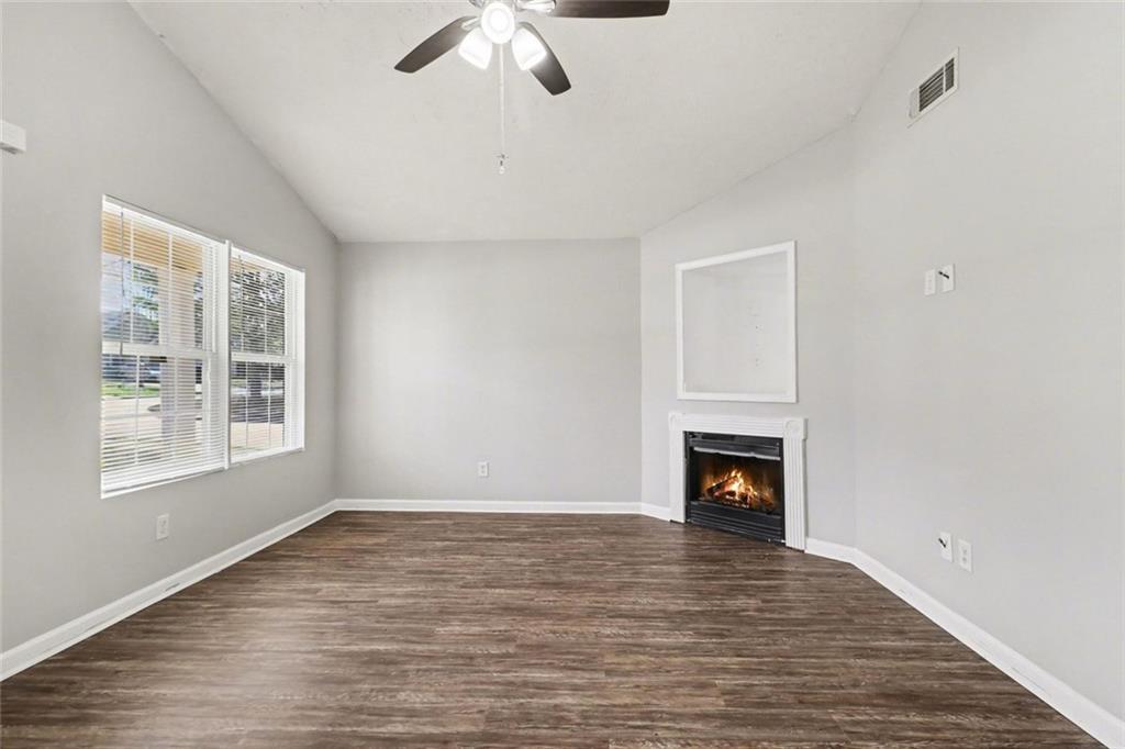 6279 Avery Street Southwest Covington, GA 30014 - Photo 5 of 21 a view of an empty room with wooden floor fireplace and a window