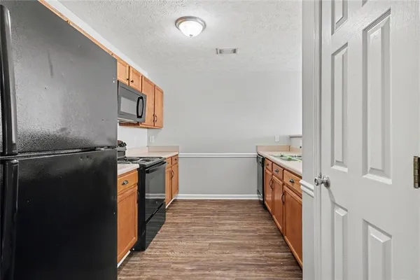 a kitchen with granite countertop a refrigerator and a stove