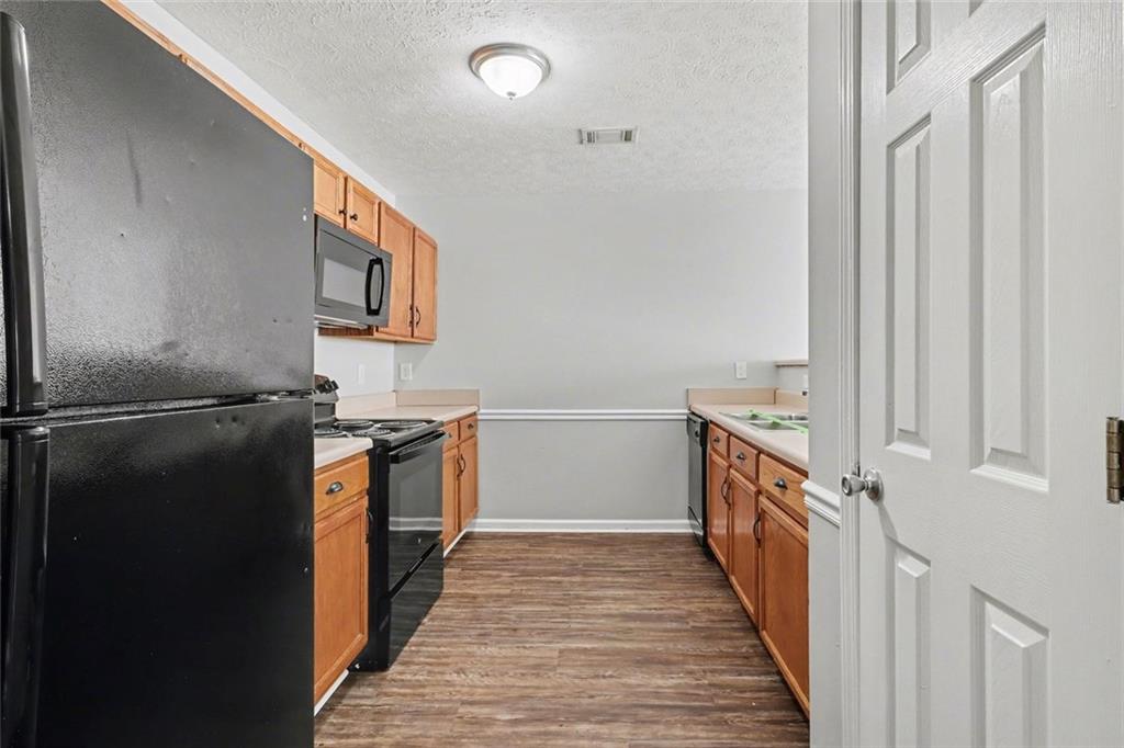6279 Avery Street Southwest Covington, GA 30014 - Photo 8 of 21 a kitchen with granite countertop a refrigerator and a stove