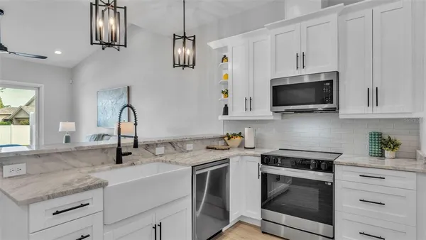 a kitchen with stainless steel appliances a refrigerator sink and microwave