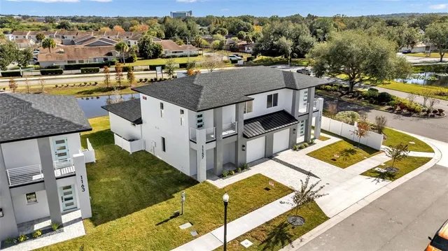 an aerial view of residential houses with outdoor space and parking