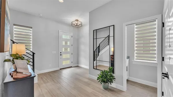 a view of a hallway with wooden floor and a window