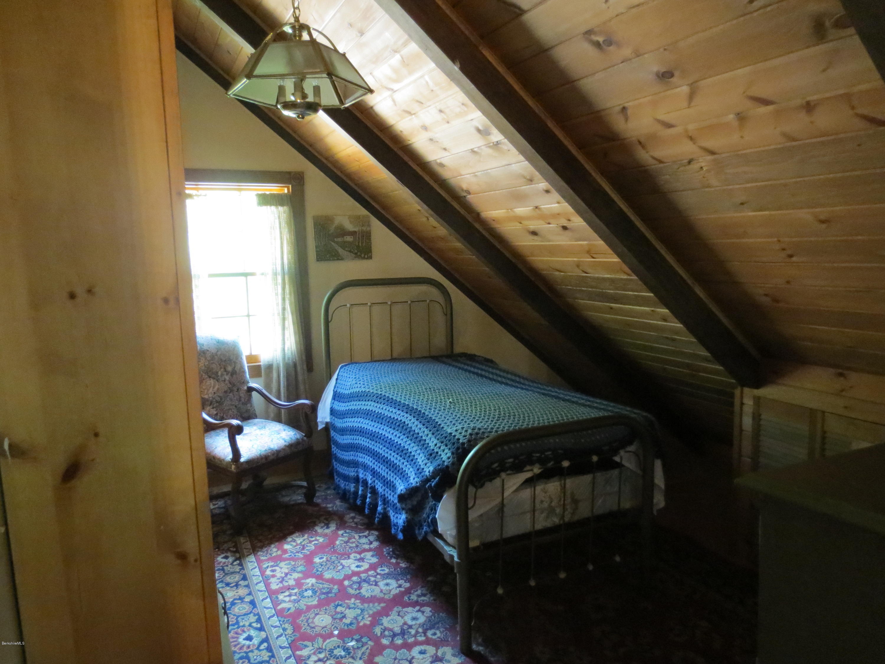 87 Crane Road Chester, MA 01011 - Photo 12 of 16 a bedroom with a bed next to a window