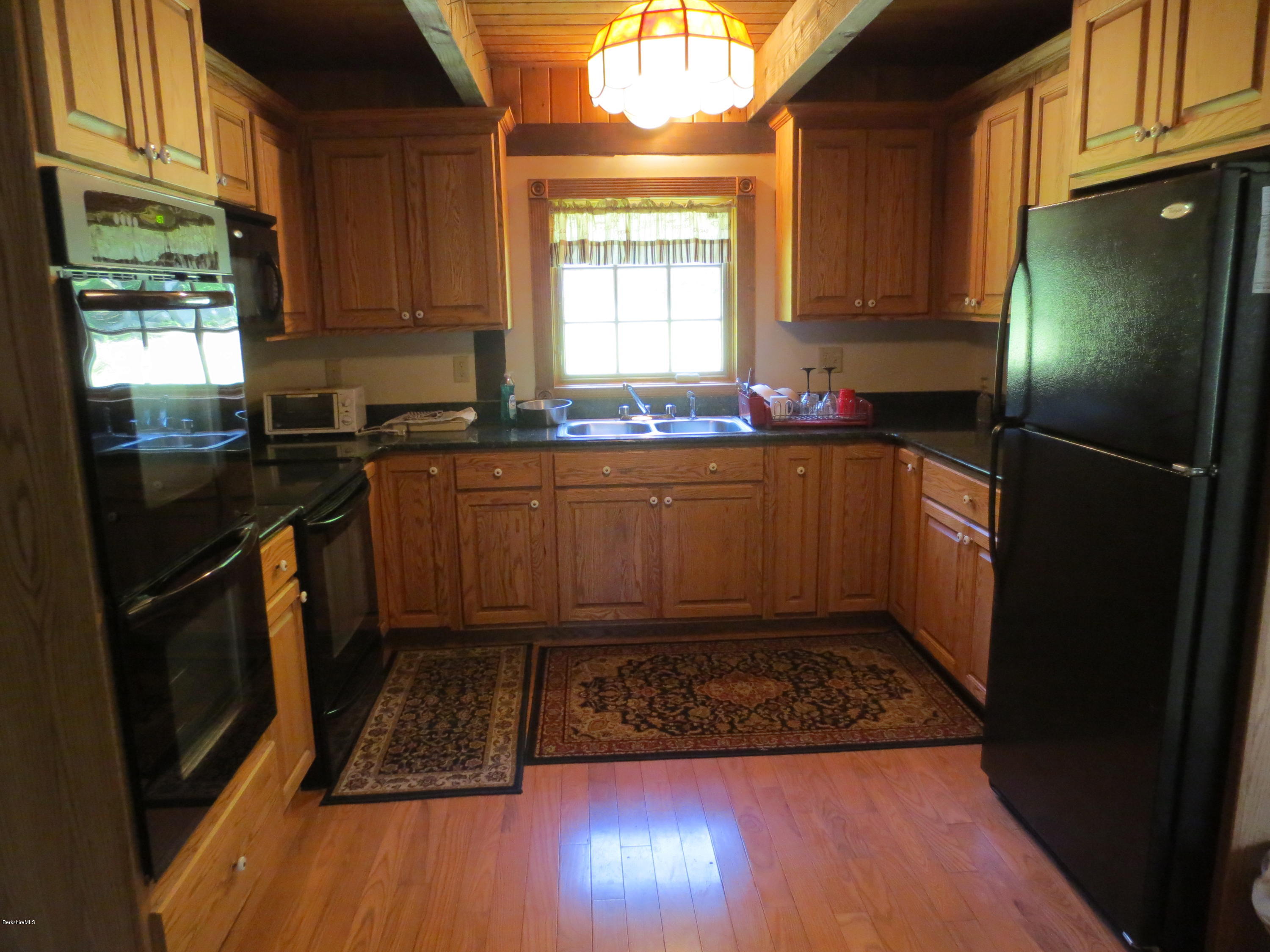 87 Crane Road Chester, MA 01011 - Photo 4 of 16 a kitchen with granite countertop a refrigerator a sink a stove and cabinets