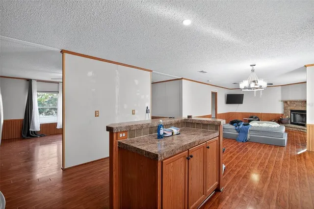 a kitchen with granite countertop a stove and a wooden floor