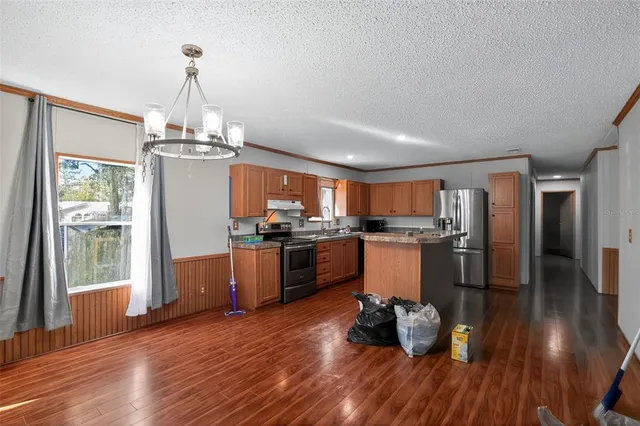 a kitchen with stainless steel appliances granite countertop a refrigerator and microwave