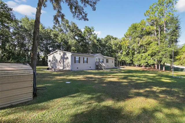 a view of a house with backyard and sitting area