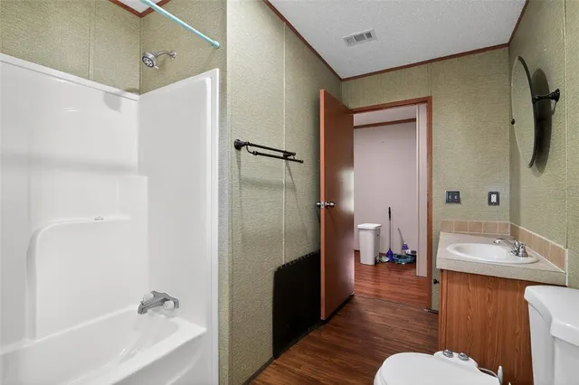 a view of a livingroom with wooden floor and a ceiling fan