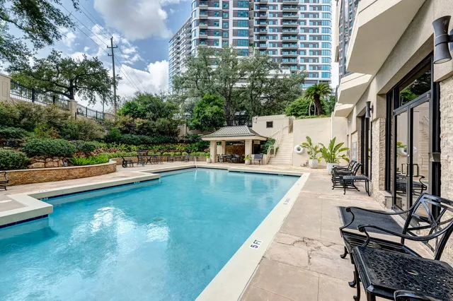 a view of swimming pool with outdoor seating and plants