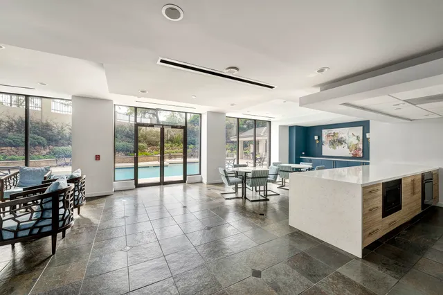 a large kitchen with stainless steel appliances a stove a sink and a refrigerator