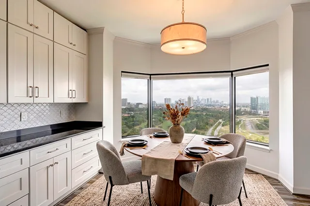 a kitchen with stainless steel appliances granite countertop a stove a sink and white cabinets with wooden floors