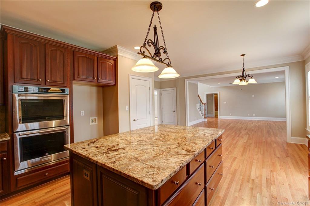 272 Hemmingway Lane Fort Mill, SC 29708 - Photo 6 of 24 a kitchen with kitchen island granite countertop wooden floor stainless steel appliances and cabinets