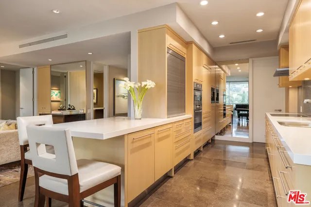 a large white kitchen with a large window and stainless steel appliances