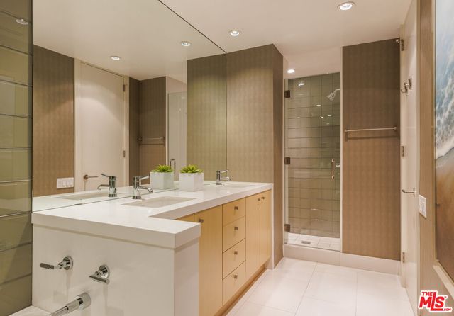 a bathroom with a double vanity sink mirror and shower