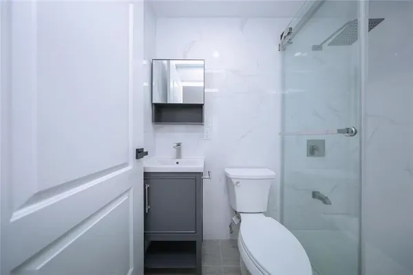 a bathroom with a toilet sink vanity and mirror